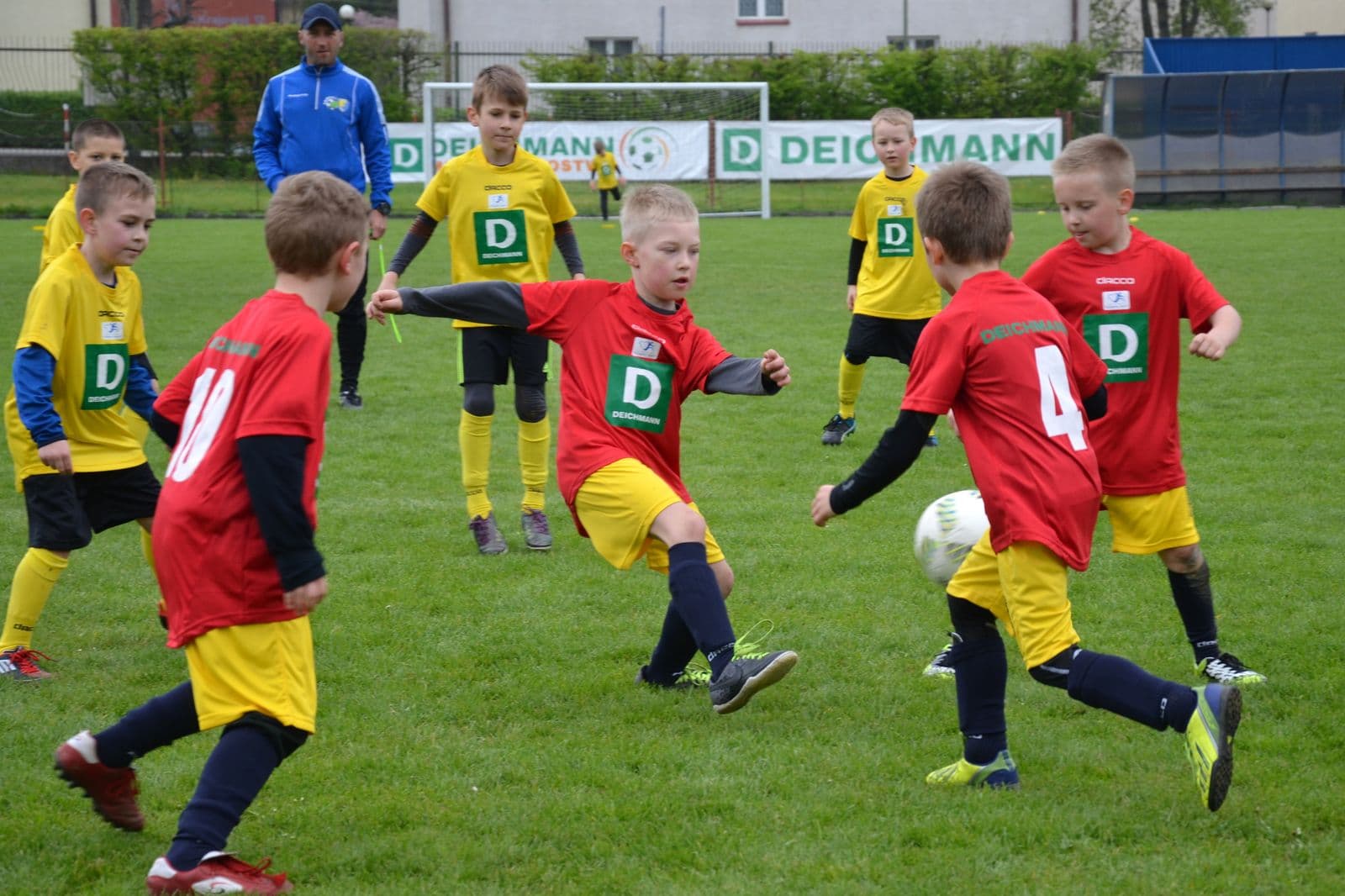 Children in red and yellow kits playing football