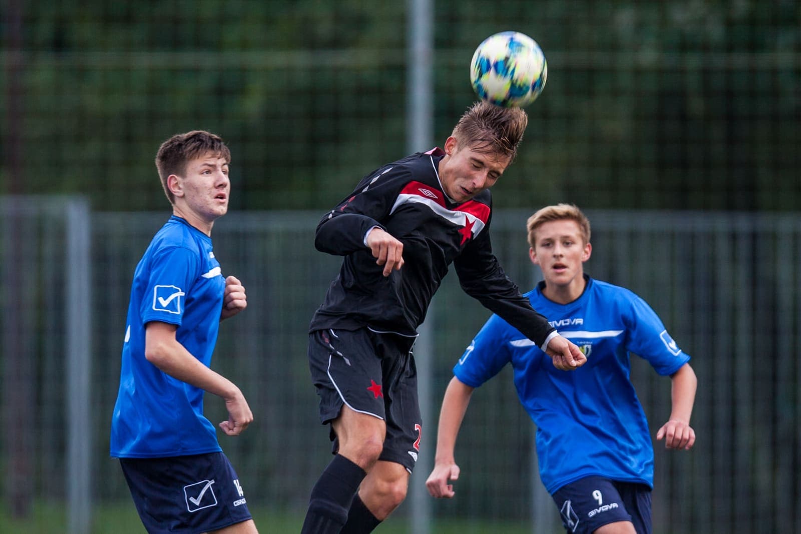 Youth footballer heading the ball during a match