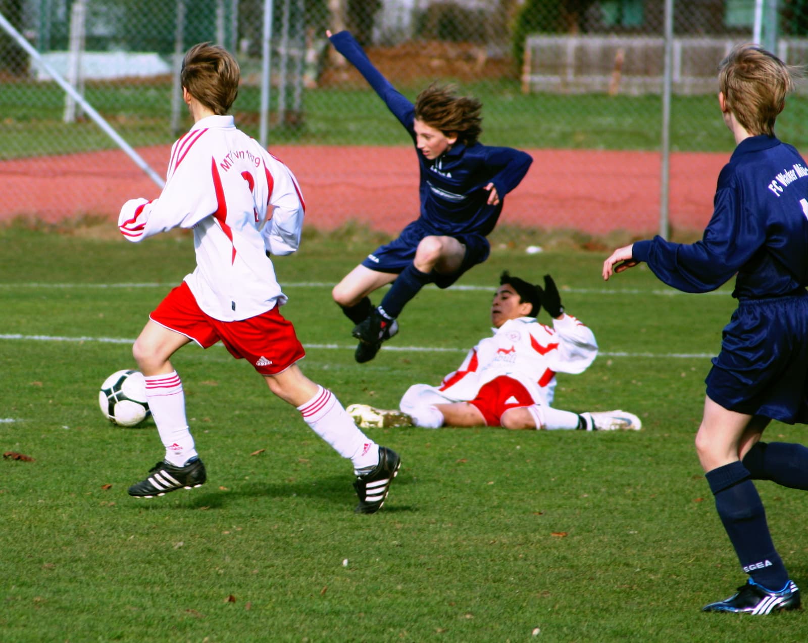 Youth football match action with players contesting the ball
