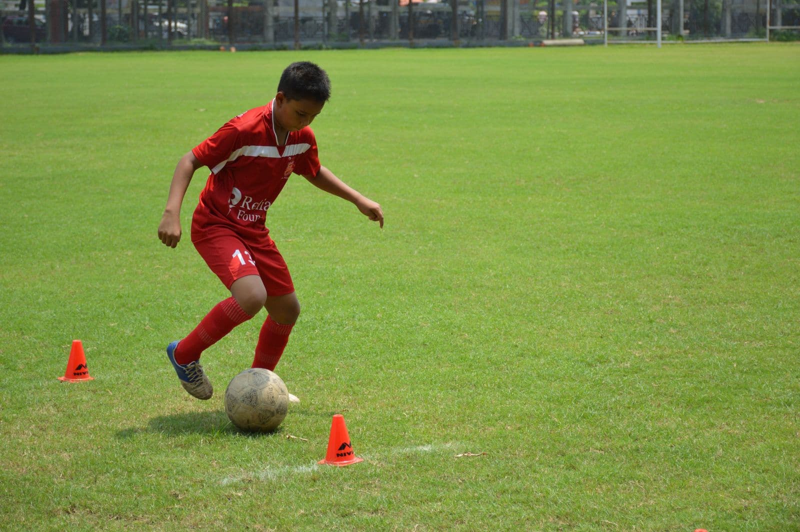Young footballer dribbling during skills test in Kolkata