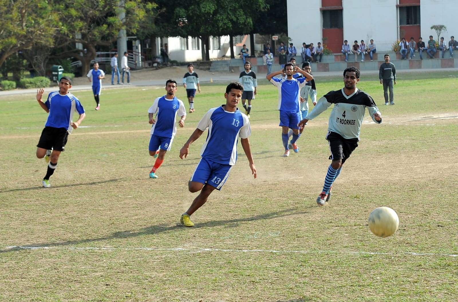 Footballers contesting the ball during a match at an Indian college ground