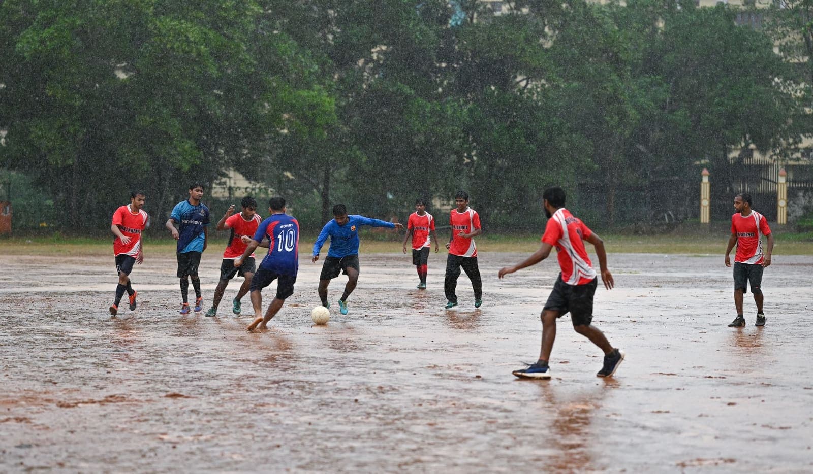 Soccer game in the rain on an Indian field