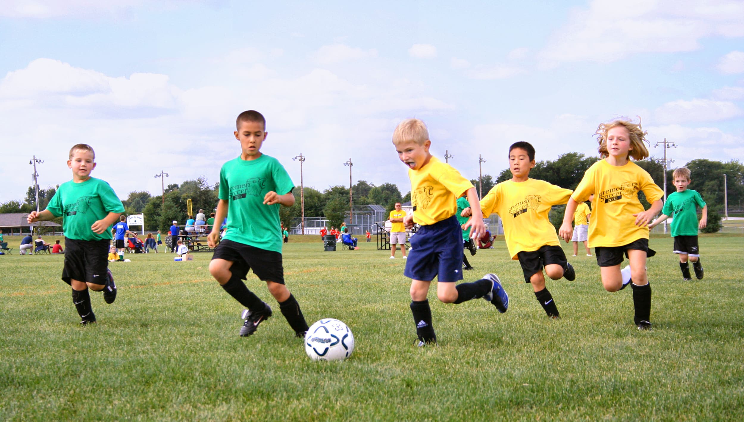 Youth football training drill with cones and ball.