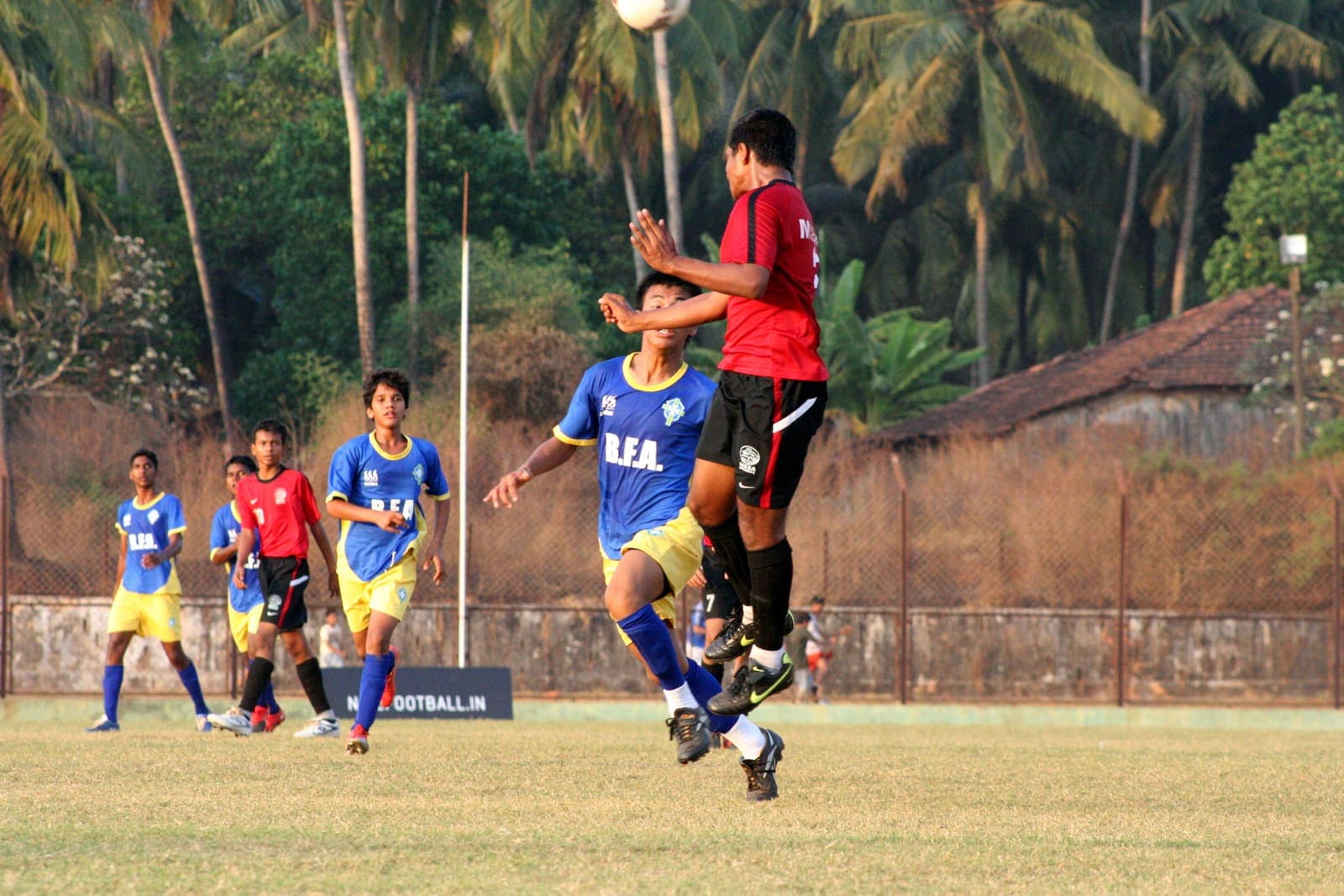 Indian footballer jumping to contest a high ball during a match in Goa