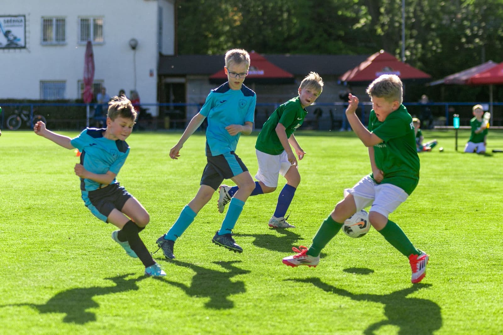 Young children playing football with the ball at a player’s feet