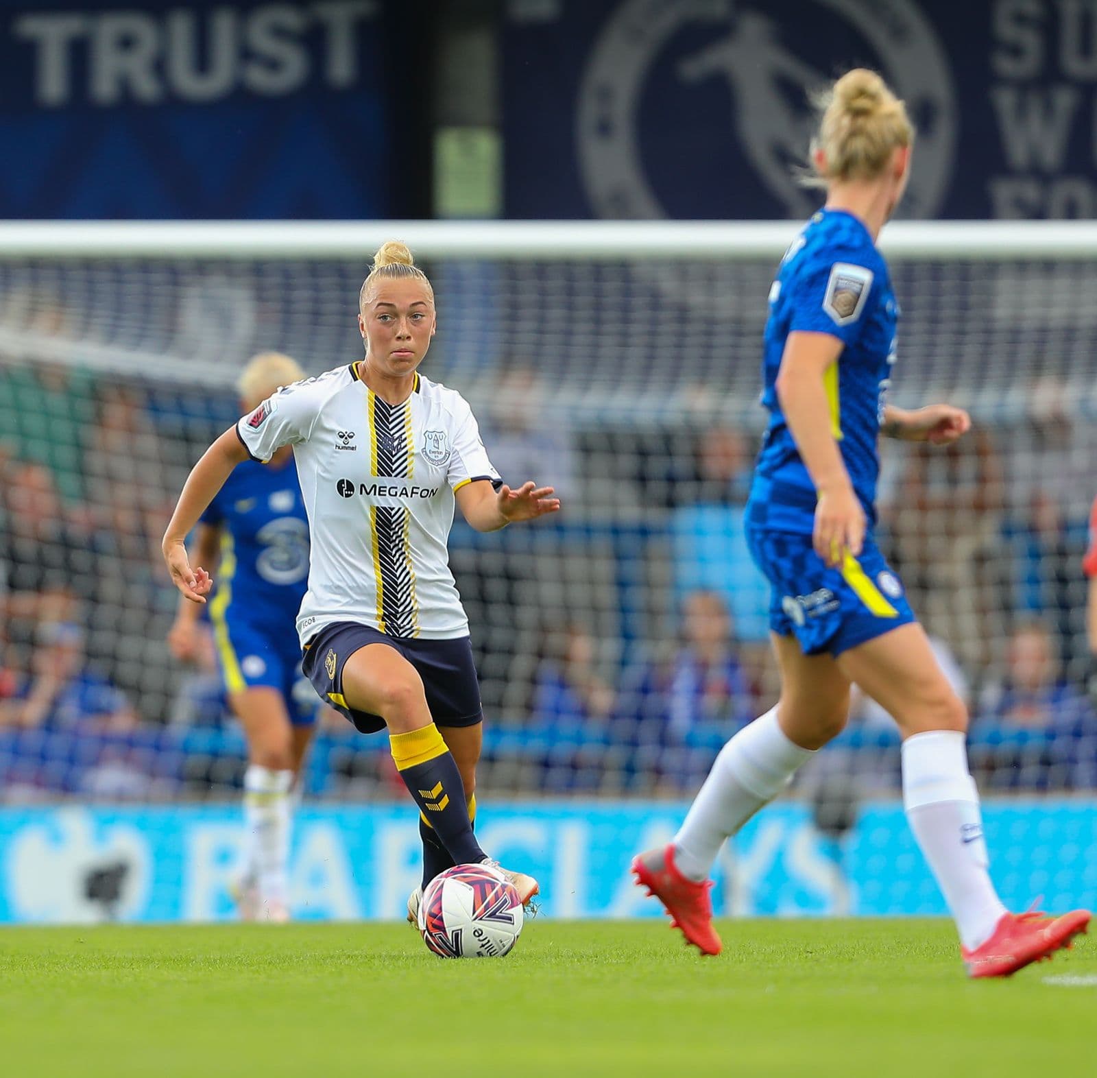 Women’s footballer dribbling the ball during a match